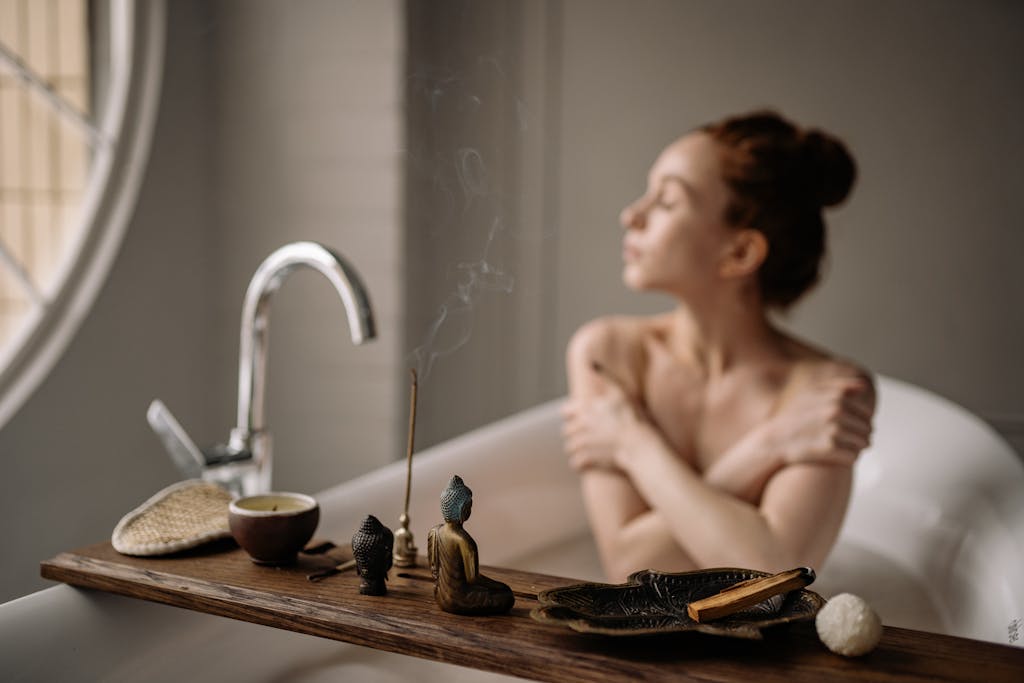 A serene bath scene featuring a woman enjoying relaxation with incense and a warm cup of tea.